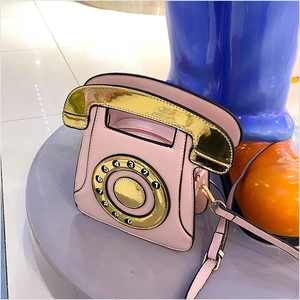 Détail du sac à bandoulière téléphone rose avec cadran rotatif et poignée dorée