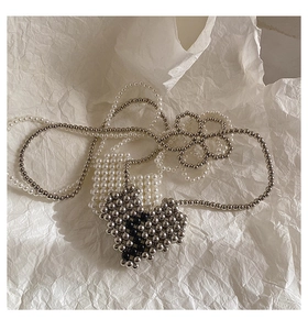 Detailed view of handmade heart-shaped beaded charm with elegant pearl chain accents