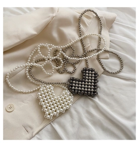 Detailed view of woven heart-shaped pearl and metallic bead crossbody mini bags