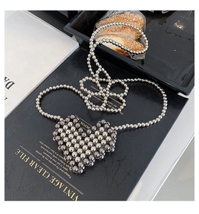 Detailed view of heart-shaped woven silver bead bag with long stylish chain strap