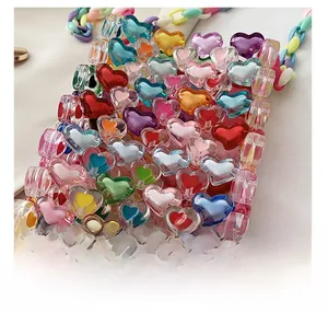 Detail of colorful acrylic heart-shaped beads on a handmade woven crossbody bag