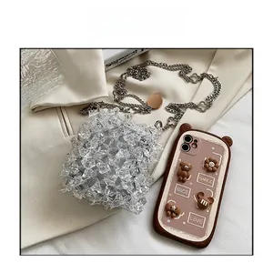 Detail of transparent crystal mini bag with metal chain and 3D floral phone case accessory