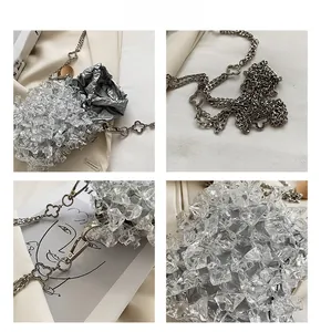 Close-up of silver drawstring bucket bag with crystal accents and clover chain detail
