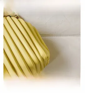 Detailed close-up of yellow pleated cloud bag leather and metallic chain strap