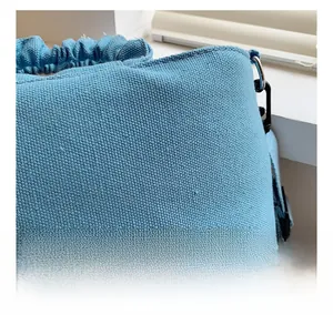 Detail of blue twill canvas fabric with drawstring pleats and black metal hook