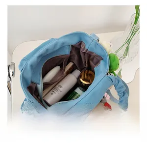 Detailed interior of blue canvas tote bag showing large capacity and soft plush charms
