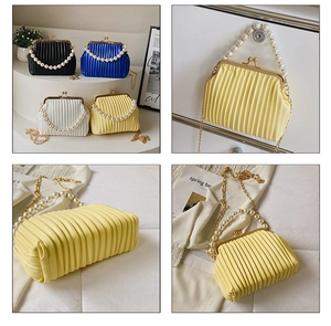 Detail of elegant pleated handbag with pearl handle and golden chain strap for women