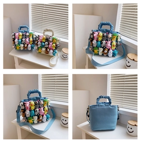 Detail showing the pleated handle and multiple colorful plush toys on canvas tote bag