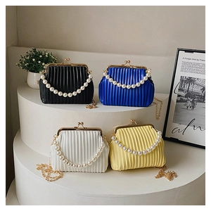 Detailed view of pleated leather handbags with pearl handles and metal chains in four colors