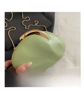 Detailed close-up of light green oval acrylic clutch bag with premium gold metal clasp