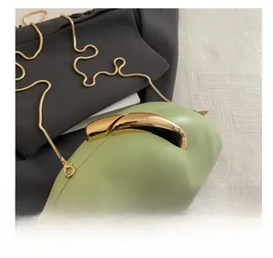 Detail view of light green acrylic clutch bag with streamlined gold clasp and chain strap