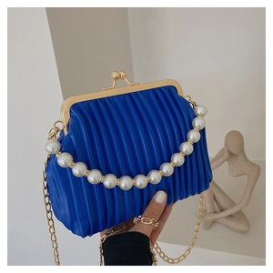 Detailed view of Klein blue pleated shell bag with pearl handle and gold clasp closure