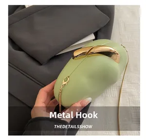 Detailed close-up of light green cloud-shaped bag with elegant gold metal clasp and chain