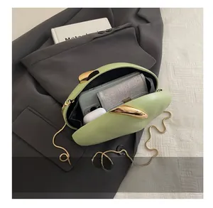 Detail shot showing internal capacity of the oval acrylic clutch with chain strap