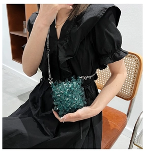 Detailed view of dark green acrylic crystal beaded mini bag with silver flower chain link