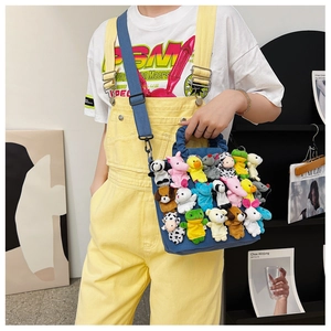 Detail of blue denim bag adorned with colorful mini plush animal dolls for unique style
