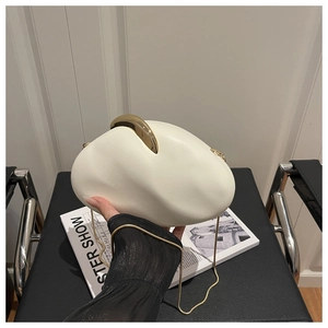 Close-up of white egg-shaped acrylic evening bag with gold metal handle and chain