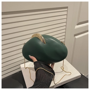 Detail of dark green egg-shaped acrylic clutch with gold clasp and chain strap
