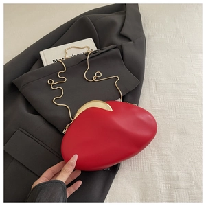 Detail of red acrylic evening bag with gold metal clasp on grey suit jacket background