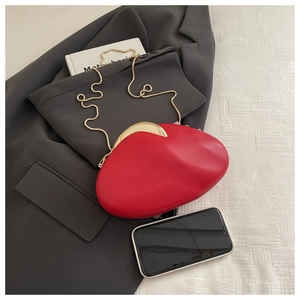 Detail view of red oval acrylic evening clutch with gold snake chain on a blazer