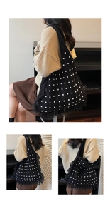 Detail view of large black knit tote bag featuring elegant pearls and long fringe trim