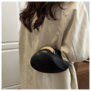 Detail of elegant black oval acrylic evening bag with gold crescent clasp and chain strap