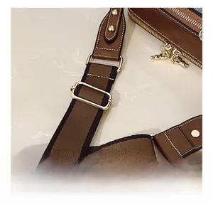 Detail showing adjustable brown faux leather strap with golden buckles and metal bear pendant