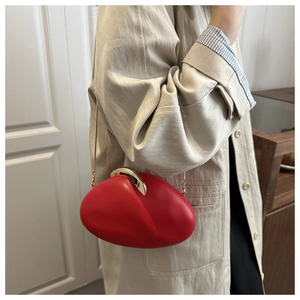 Detail of red egg-shaped acrylic evening bag with gold lava clasp and chain strap