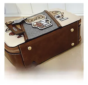 Detail view of the brown leather bag base showing four gold protective metal rivets