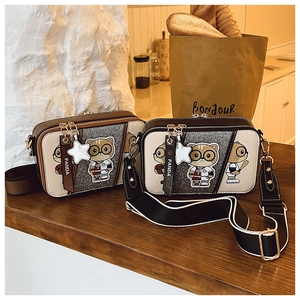 Detail of cartoon cat camera bags with sequin texture and wide contrast straps