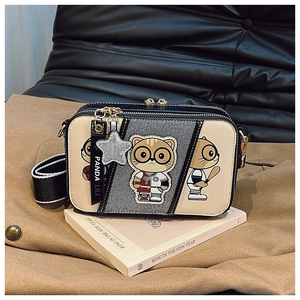 Detail of contrast crossbody bag with cute cat graphics and wide striped shoulder strap