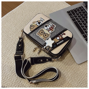 Detail shot of a cartoon cat crossbody bag with sequins and wide fabric shoulder strap