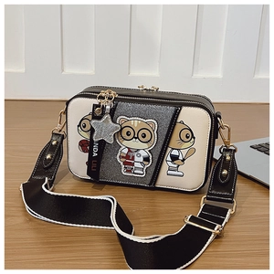 Detail view of contrast color crossbody camera bag with cartoon cat print and wide strap