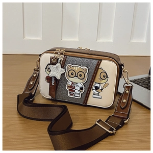 Detail of crossbody camera bag with cartoon characters and wide canvas shoulder strap