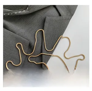 Detail showing the gold snake chain strap and luxury metallic texture of the clutch bag