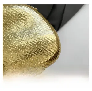 Detailed macro view of champagne gold evening bag with snake pattern texture