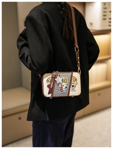 Detail of cartoon panda crossbody bag featuring silver sequins and a star pendant