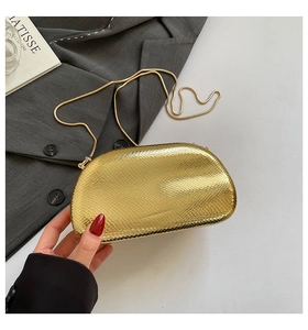 Detailed view of golden snake-skin texture on a luxury chain evening clutch bag