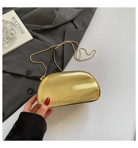 Detail of gold snake pattern dinner clutch bag with chic metallic texture and chain strap