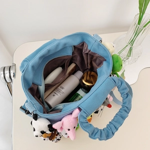 Blue canvas tote bag with plush animal dolls and spacious interior storage