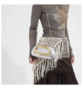 Detail of silver lizard-pattern handbag with gold U-shaped metal handle and chain strap