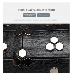 Gros plan du cuir noir grainé avec des rivets métalliques hexagonaux argentés