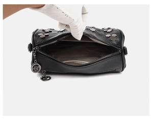 Vue détaillée du sac cylindre en cuir noir avec clous et doublure intérieure spacieuse