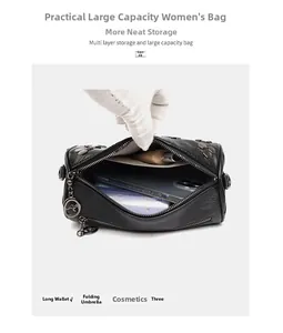 Détail du sac cylindrique noir avec rivets et pendentif kangourou spacieux