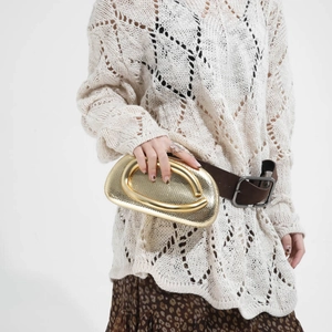 Metallic gold acrylic box bag with U-shaped handle styled with bohemian leopard skirt