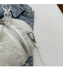 Close-up of white plush round bag with silver metal hardware and acrylic beaded handle