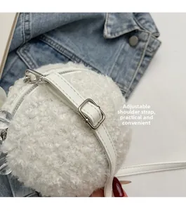 Detail of adjustable leather shoulder strap with silver buckle on white plush ball bag