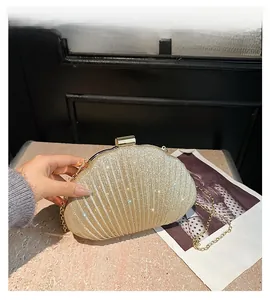 Dettaglio della pochette da sera a forma di conchiglia con glitter dorati e catena