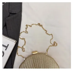 Dettaglio di elegante pochette da sera dorata con paillettes e tracolla a catena