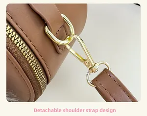 Detail view of brown leather bag with detachable shoulder strap and gold metal hook
